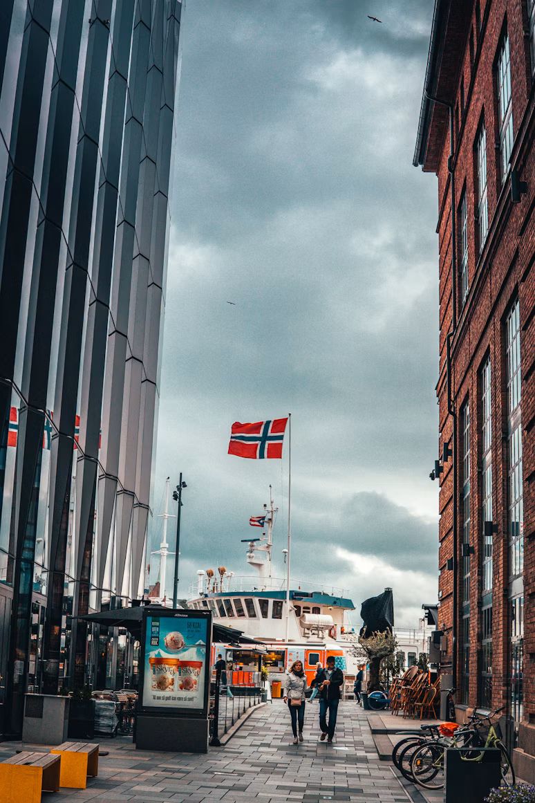 Norwegische Flagge an einem Fahnenmast zwischen Häusern