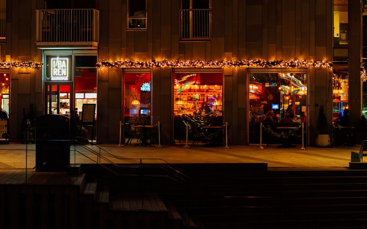 Beleuchtete Fassade eines Lokals mit Lichterketten am Abend