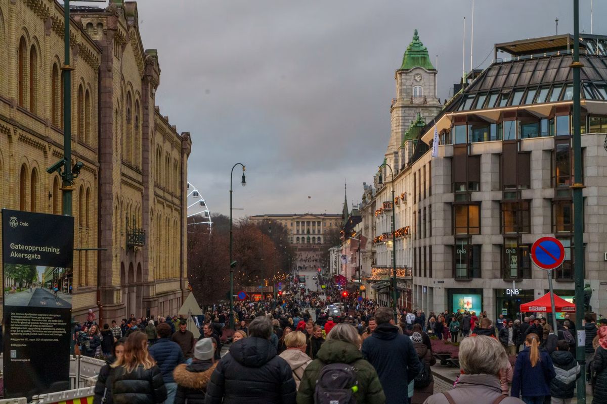 Belebte Straße im Advent mit vielen Menschen und einem Turm im Hintergrund